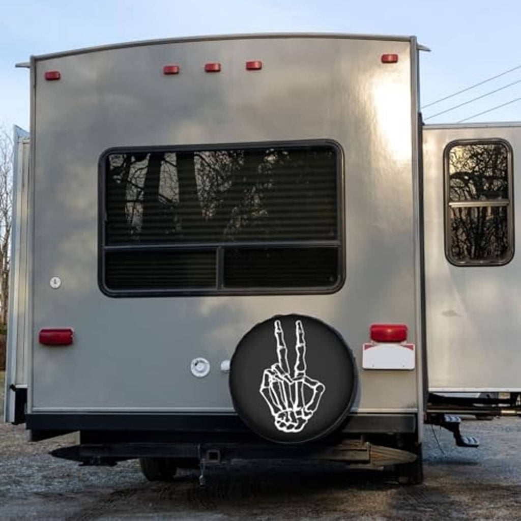 Black spare tire cover on back of van with white peace-hand graphic
