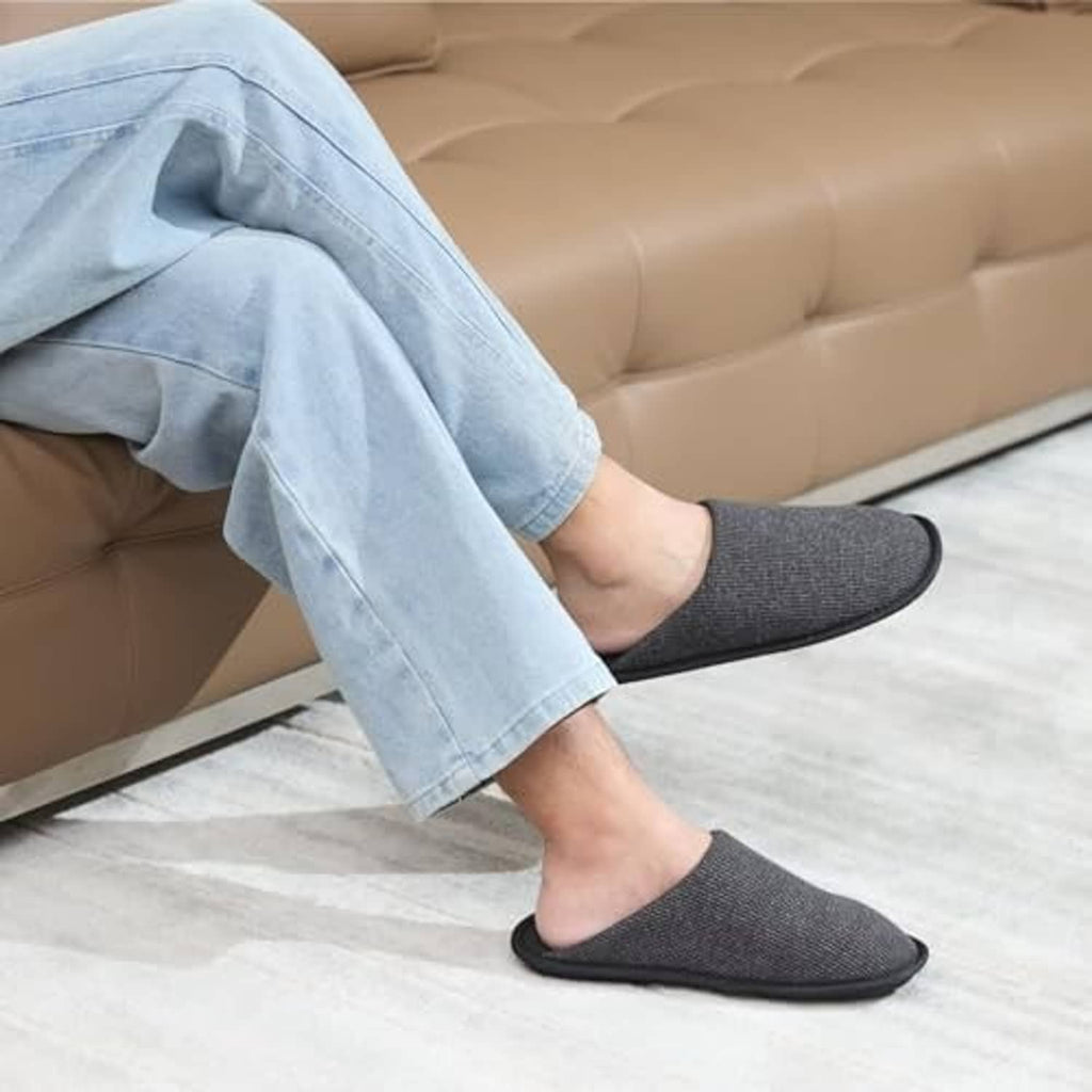 Men's black waffle-knit scuff slippers worn on feet with cushioned insole