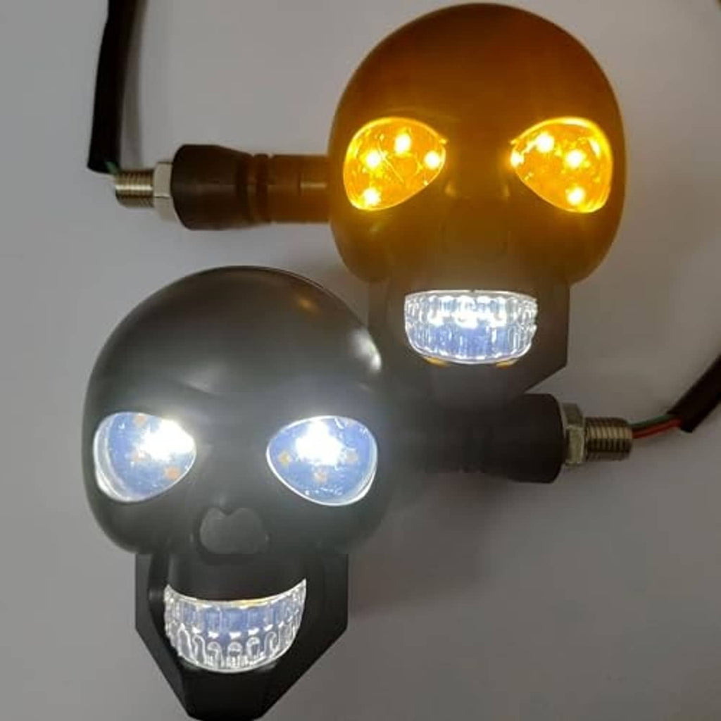 Two lit skull motorcycle turn signal lights with amber top LEDs and clear bottom lenses