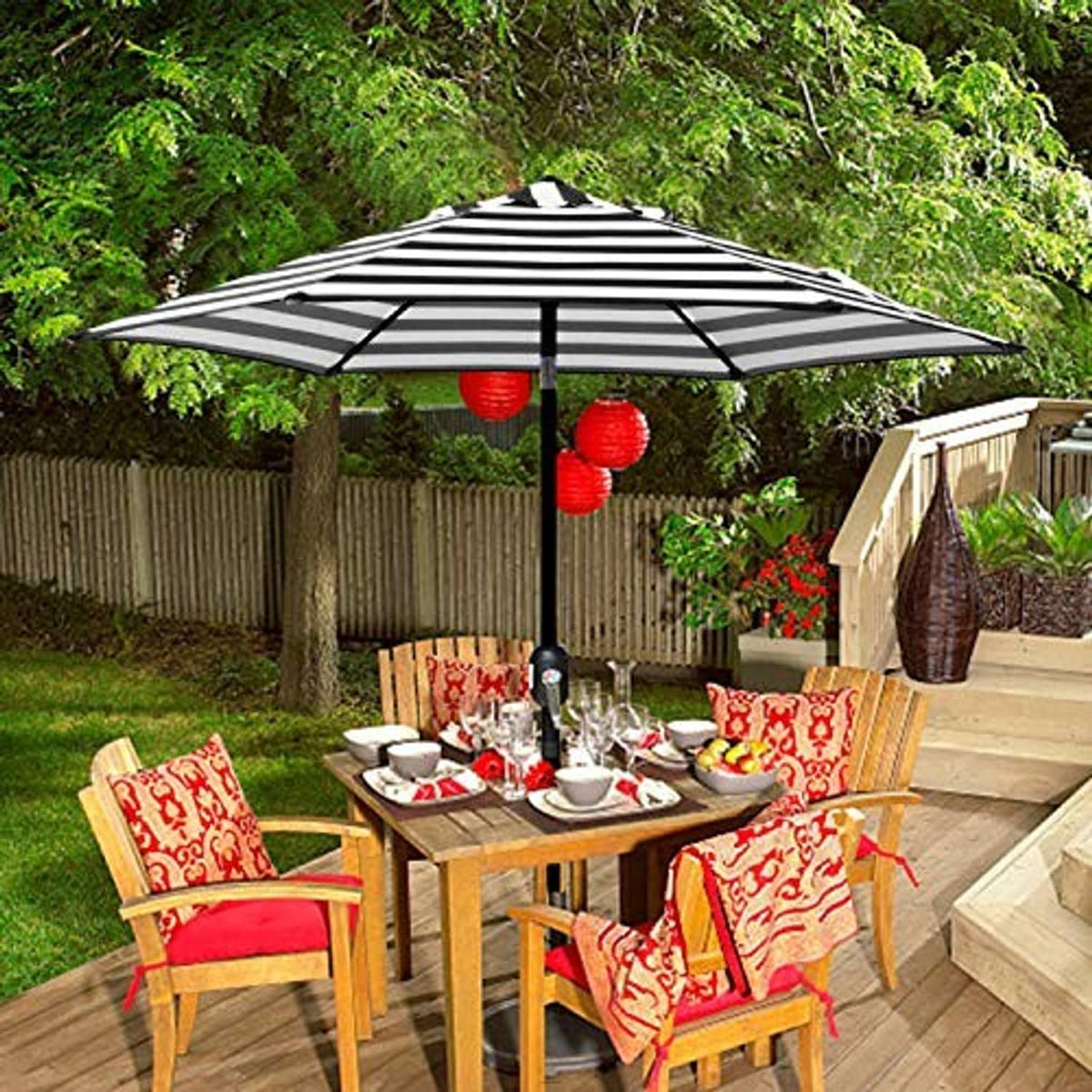 Black-and-white striped patio umbrella open in backyard over a dining table