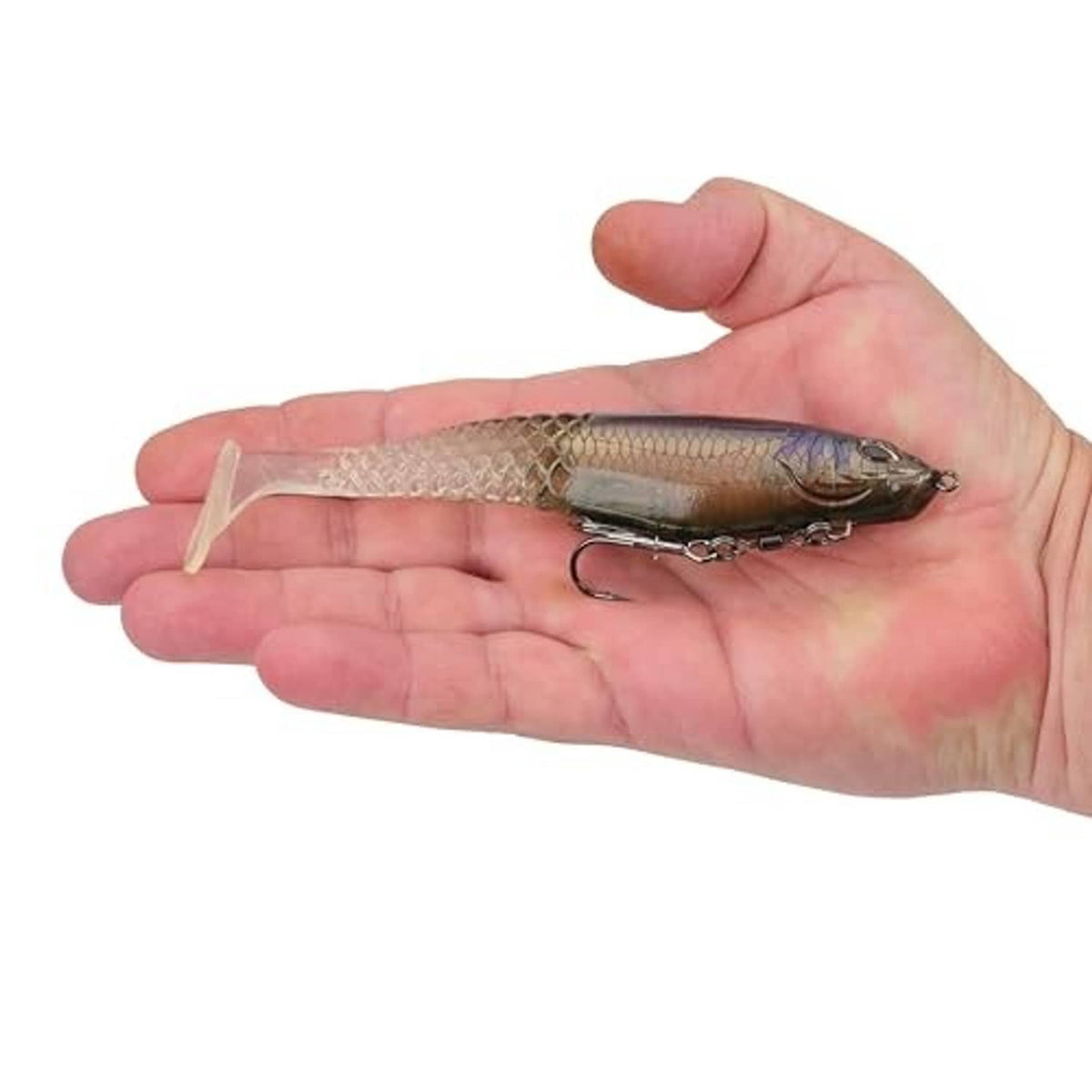 Soft plastic swimbait held in hand, translucent body with treble hook rig