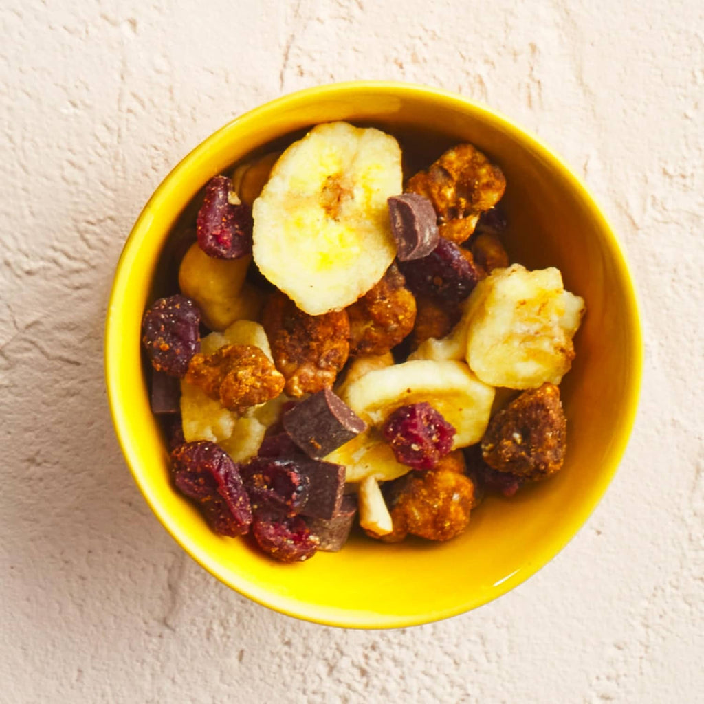 Bowl of organic Oh Mega Mix snack mix with nuts, dried fruit pieces, and chocolate