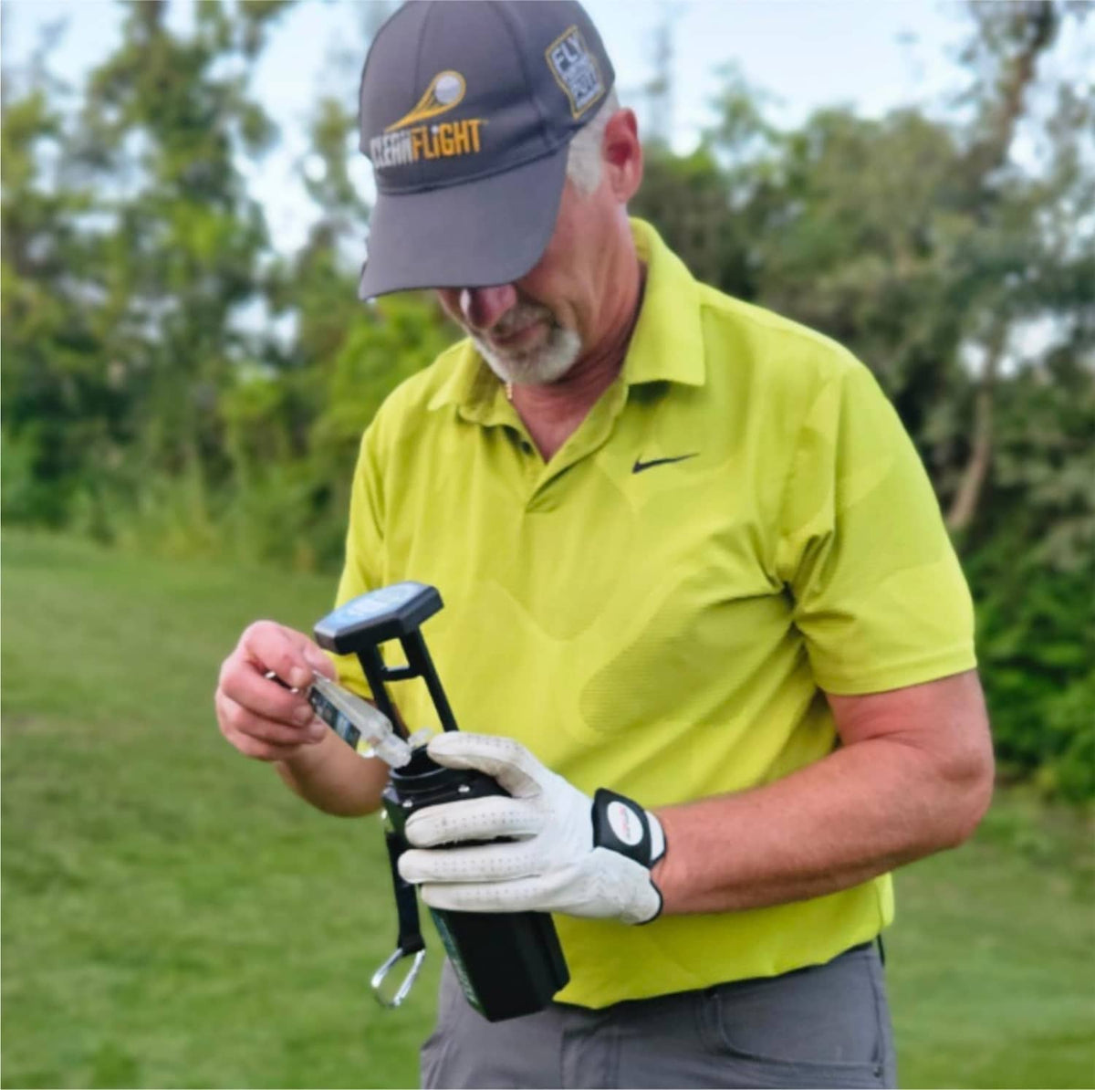 Portable Clean Flight golf ball washer held with blue cleaning cartridge