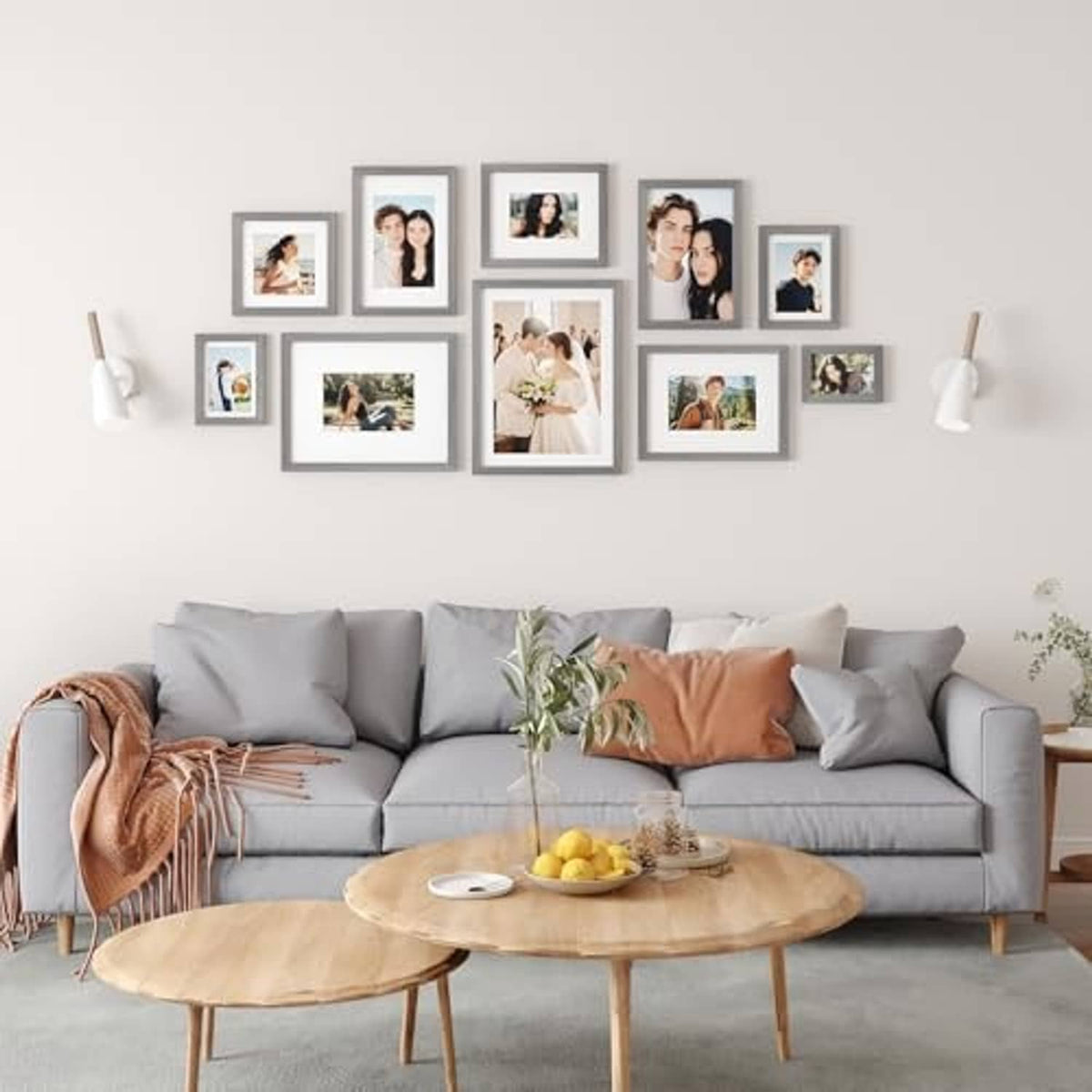 Wall display of multiple light grey solid wood picture frames in a living room