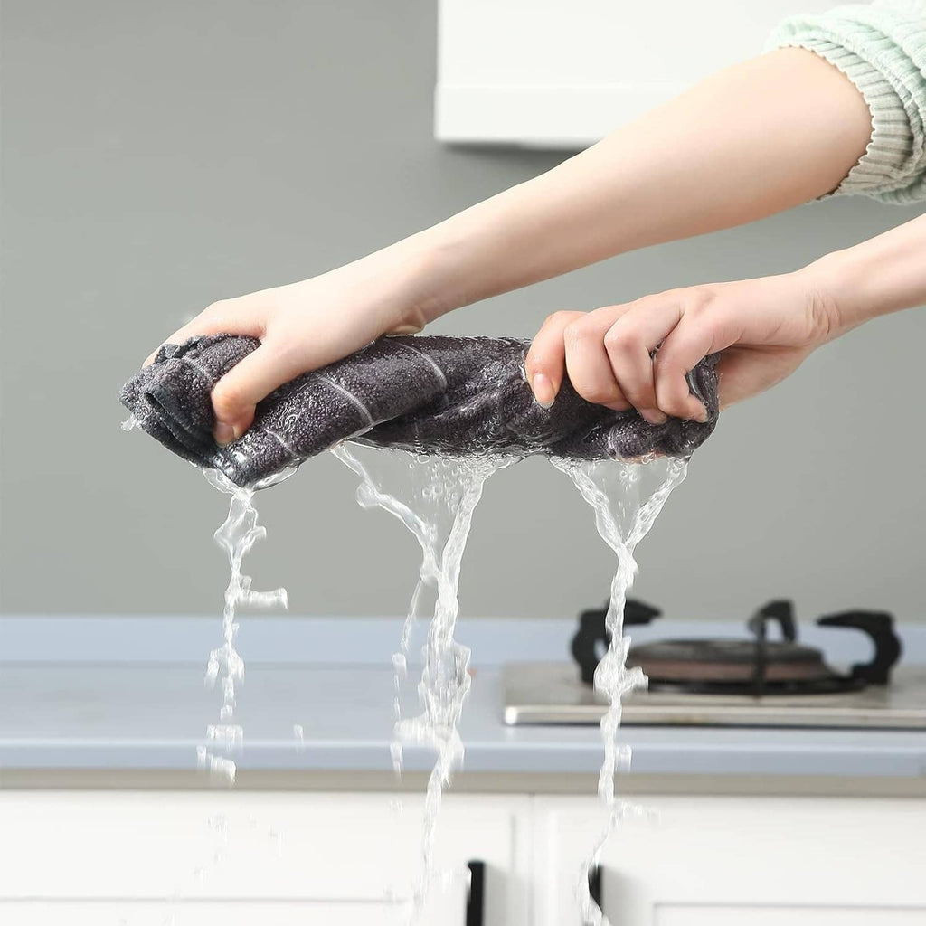 Grey microfiber dishcloth held under running water, fabric soaking view.