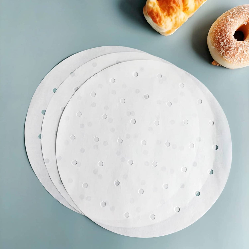 Stack of round white air fryer parchment liners with hole pattern