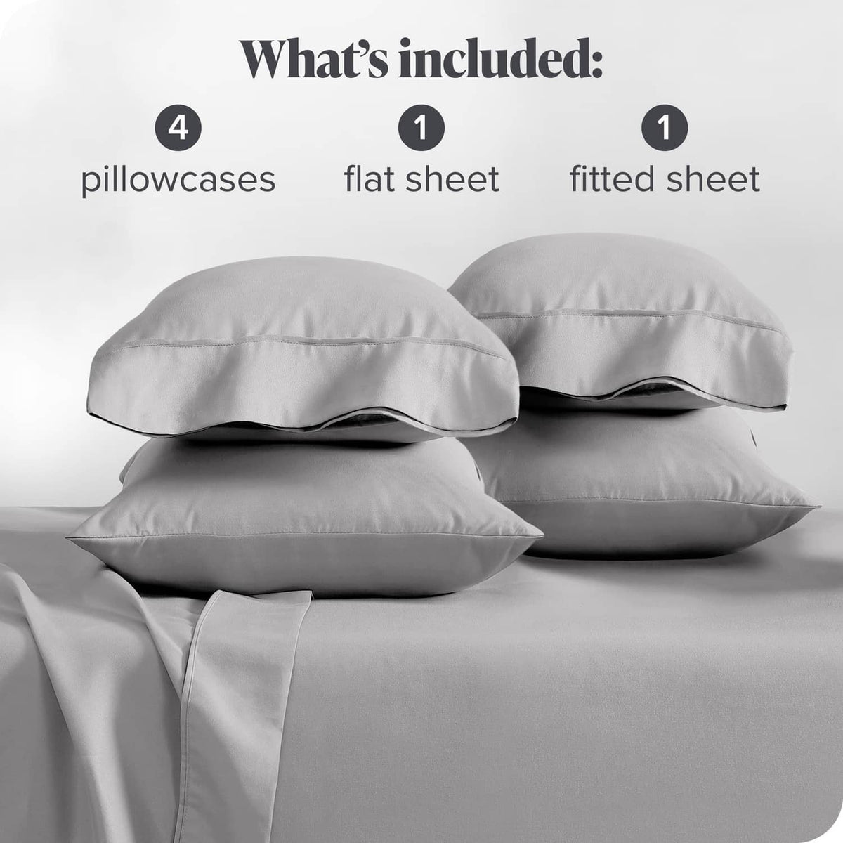 Light grey sheet set laid out: pillowcases, flat sheet, and fitted sheet