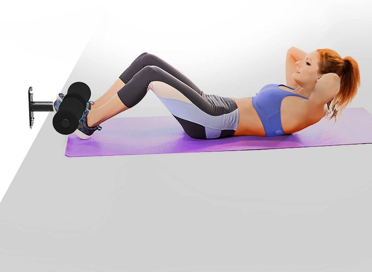 Sit-up setup using a wall-mounted foot holder with black foam pads.