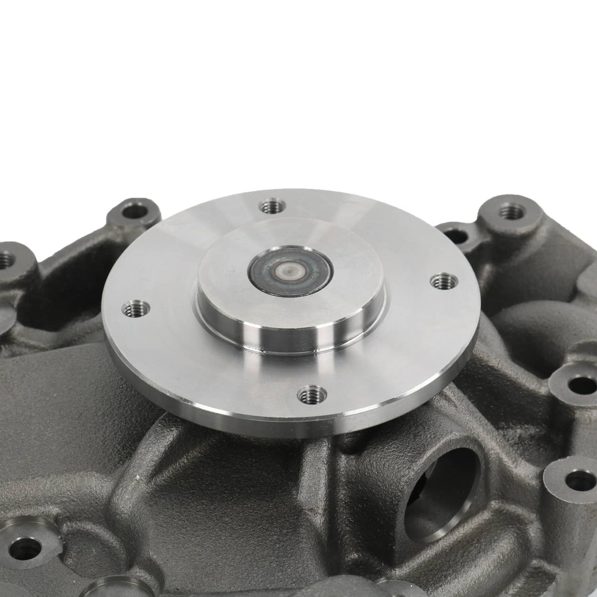 Water pump close-up showing circular plate with bolt holes and central fastener pin