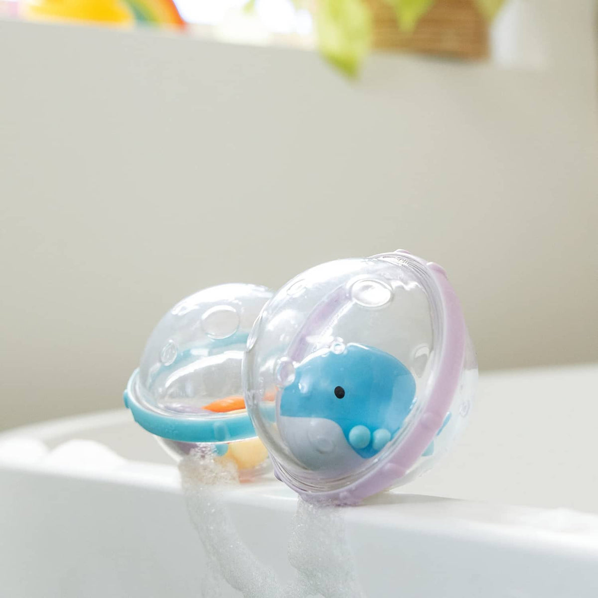 Close-up of a clear bubble float bath toy with blue whale character in water