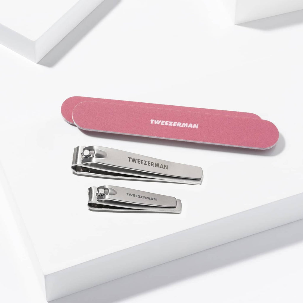 Tweezerman nail kit with rose-pink nail file and two silver nail clippers.