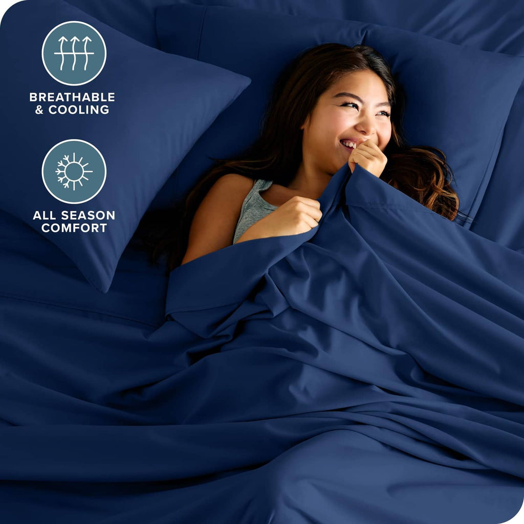 Dark blue bed sheet set with fitted sheet and pillowcases, close-up with soft folds