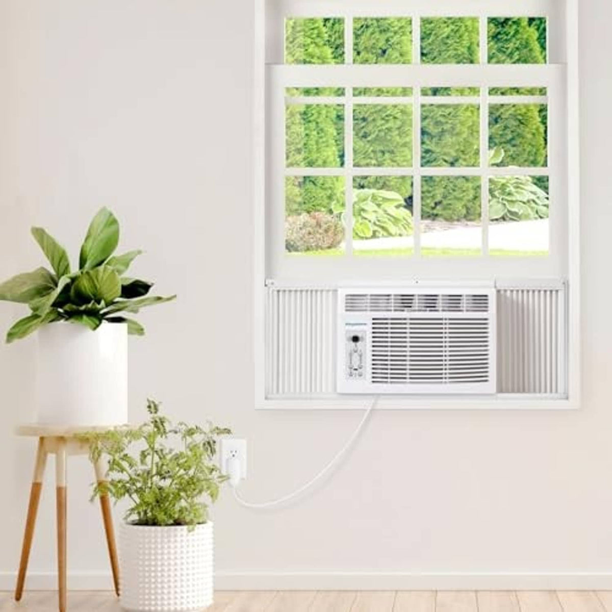 Window-mounted white air conditioner unit in a wall window opening