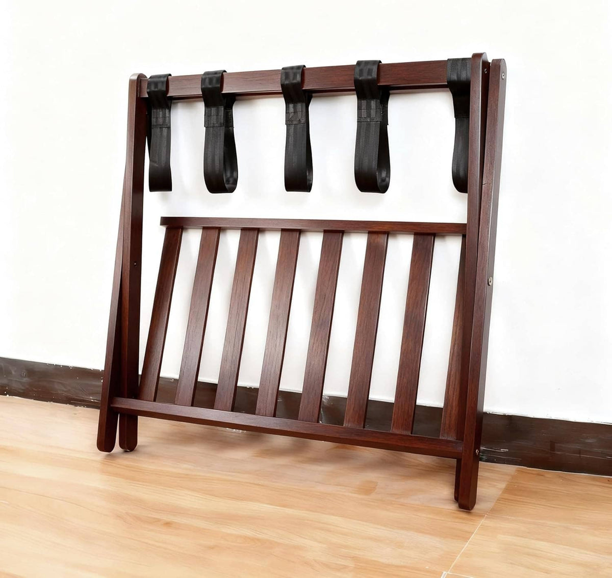 Wooden luggage stand with slatted frame and five black strap loops on the front