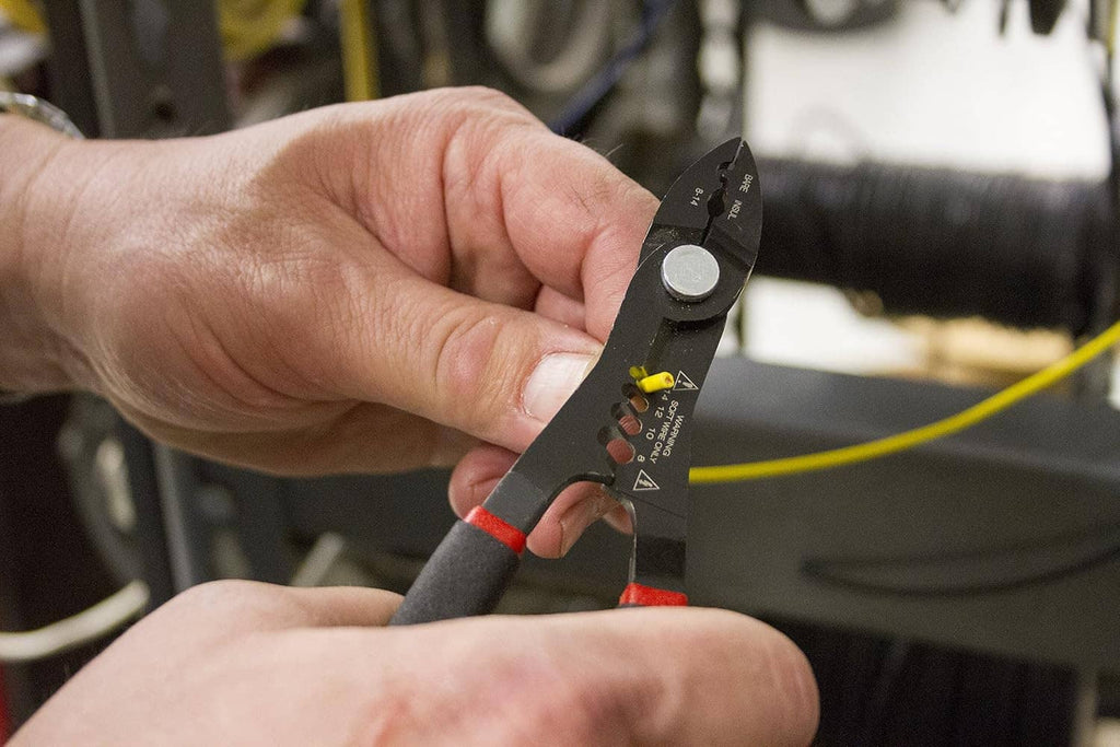 Wire stripper pliers being used to strip a wire, red-and-black handles