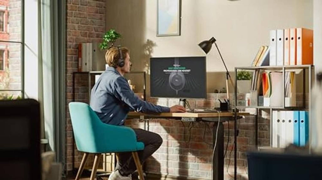 Person wearing black USB over-ear headset with microphone in home office