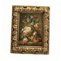 Ornate antique gold picture frame with floral artwork inside