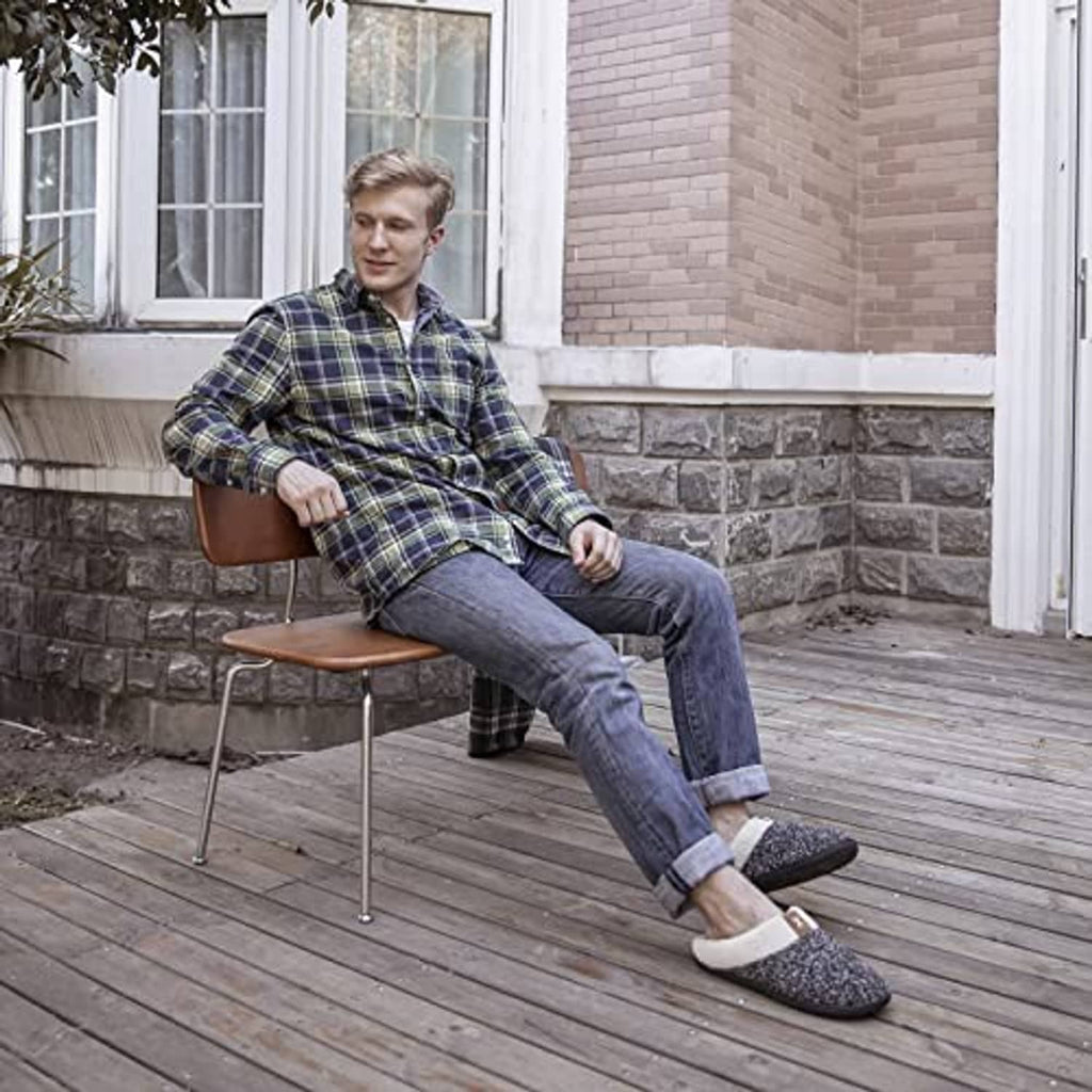 Men's sherpa-lined slip-on slippers on feet, black speckle knit with tan sherpa lining