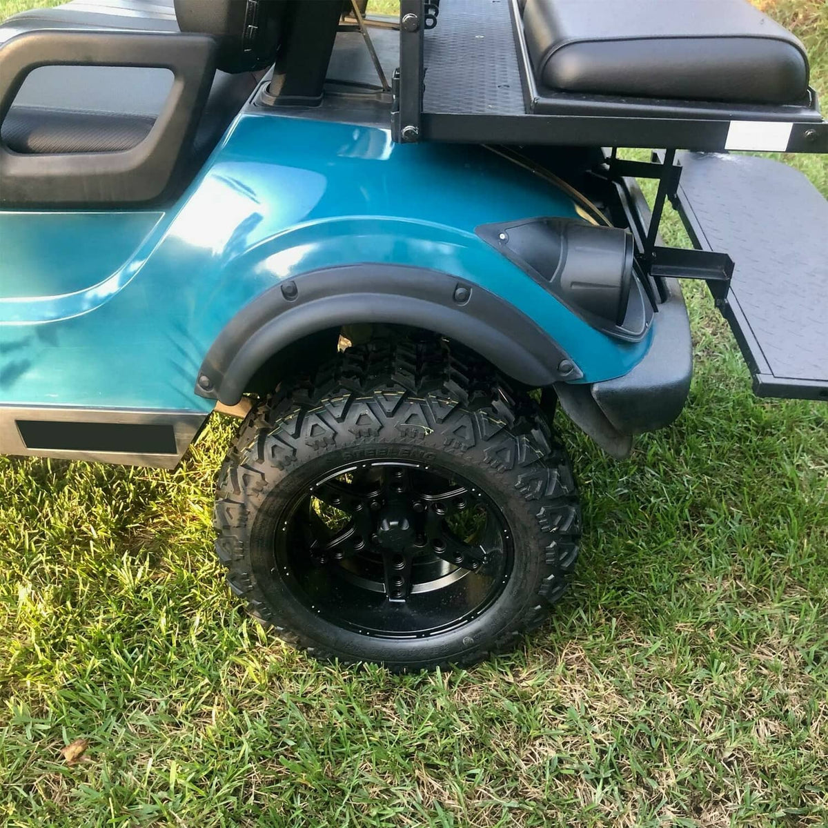Golf cart front fender flare installed near front tire, black plastic with screw points