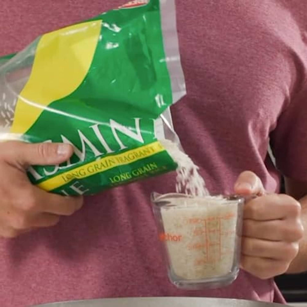 Jasmine long-grain rice bag, held near a clear measuring cup