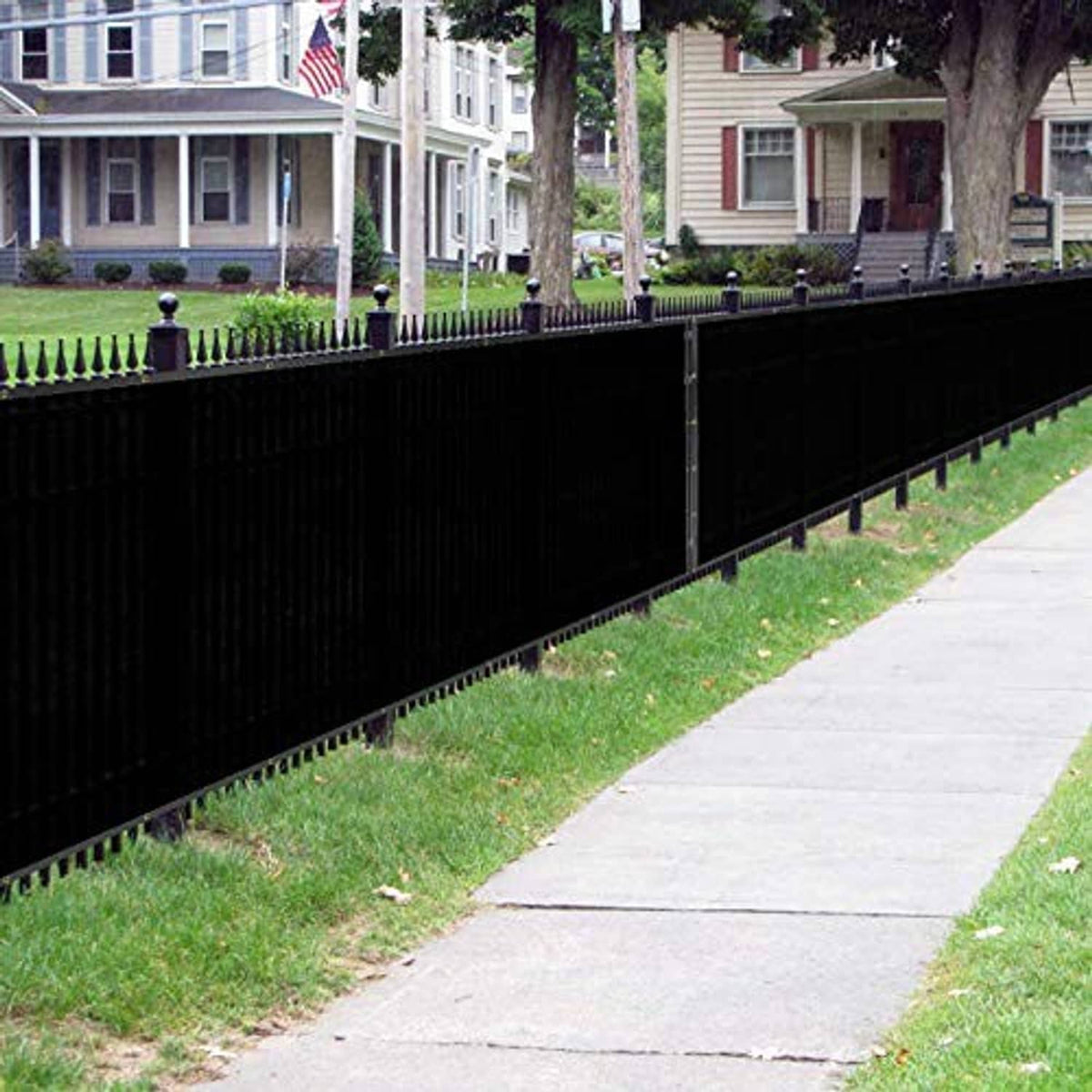 Black privacy screen fence mounted along a yard walkway