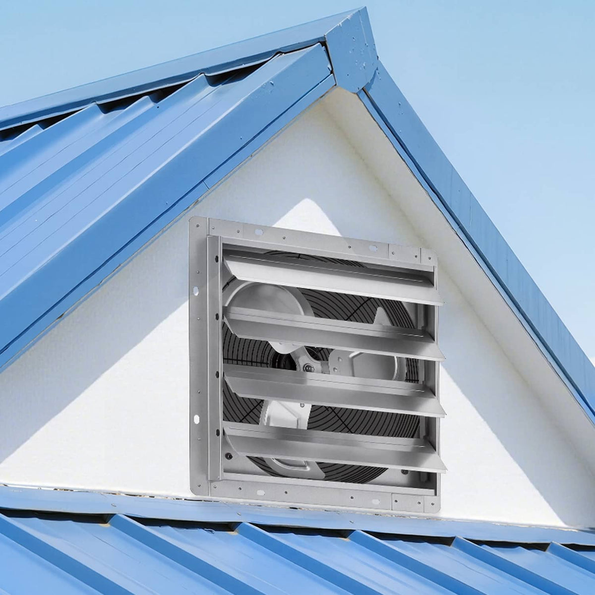 Wall-mounted 16-inch exhaust fan with louvered grille installed in an exterior wall opening
