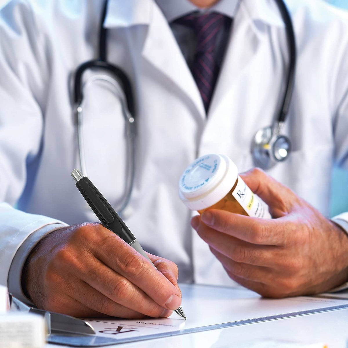 Ballpoint pen writing on a document while doctor gestures nearby