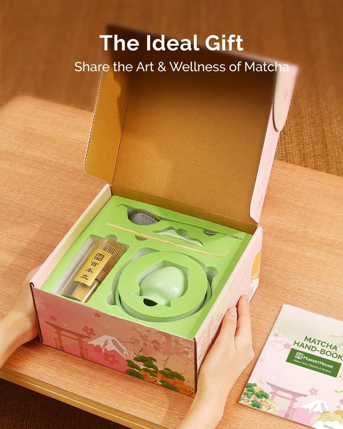 Open gift box with green matcha bowl, whisk holder, strainer, and instruction handbook