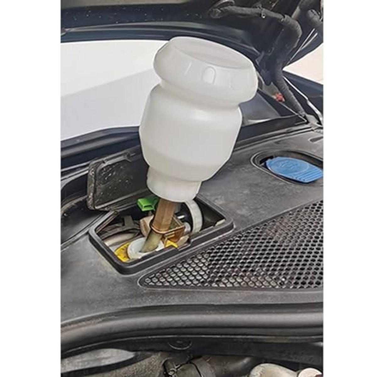 Vacuum brake bleeder bottle connected to a vehicle brake area with hoses and valve fitting