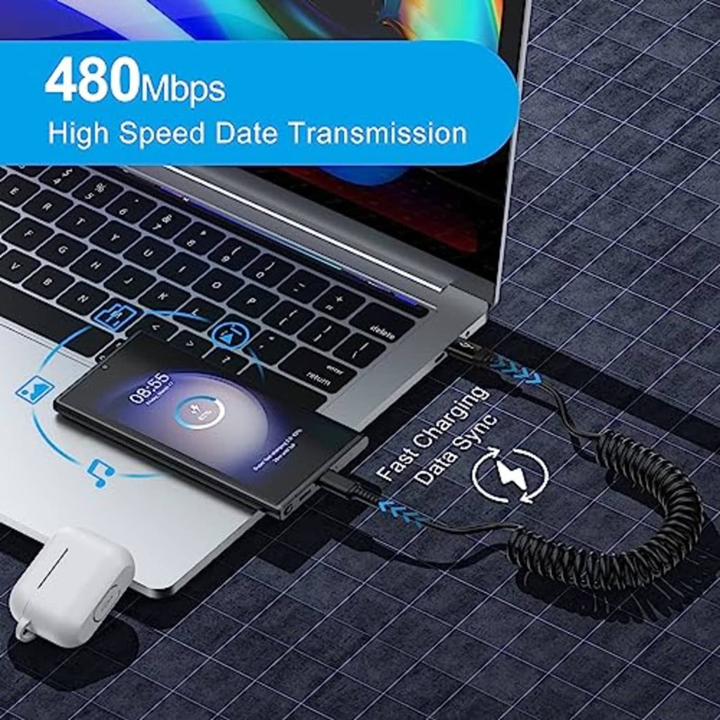 Black coiled USB-C charging cable plugged into laptop and smartphone.