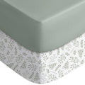 Fitted crib sheet with light green solid top and white leaf-print skirt corners