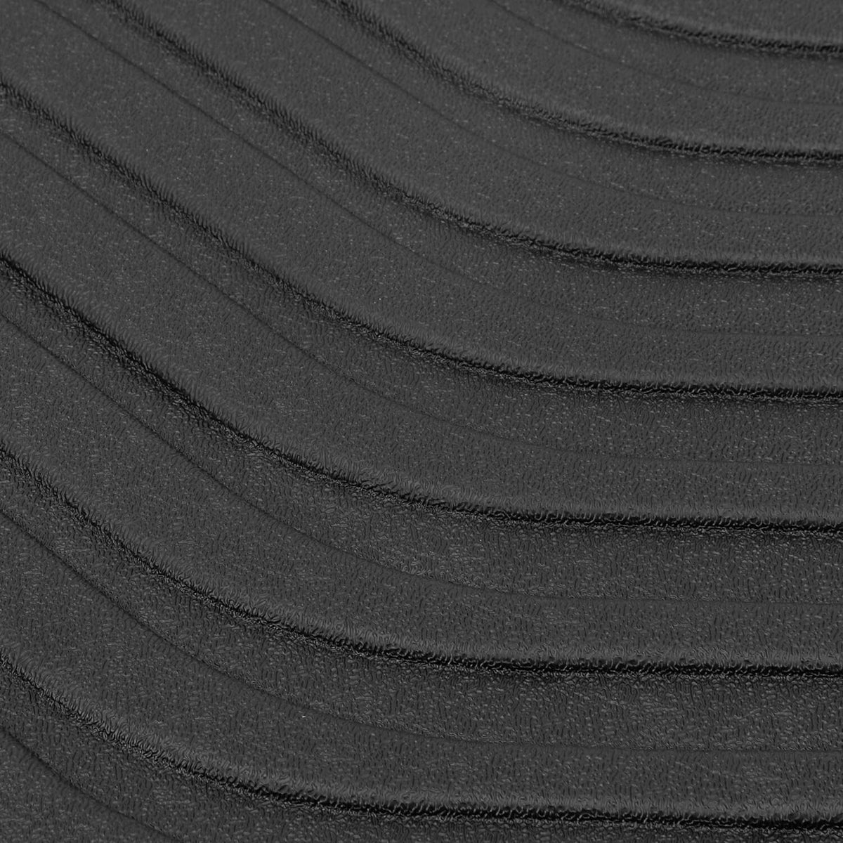 Black TPE floor mat surface with fine molded ridges and grooves, close-up