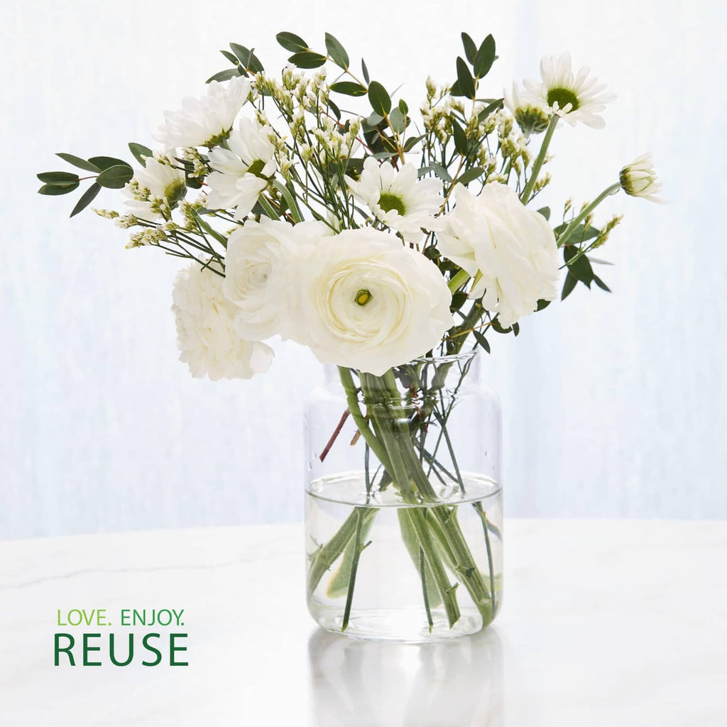 Reusable glass jar holding a bouquet of white and green flowers