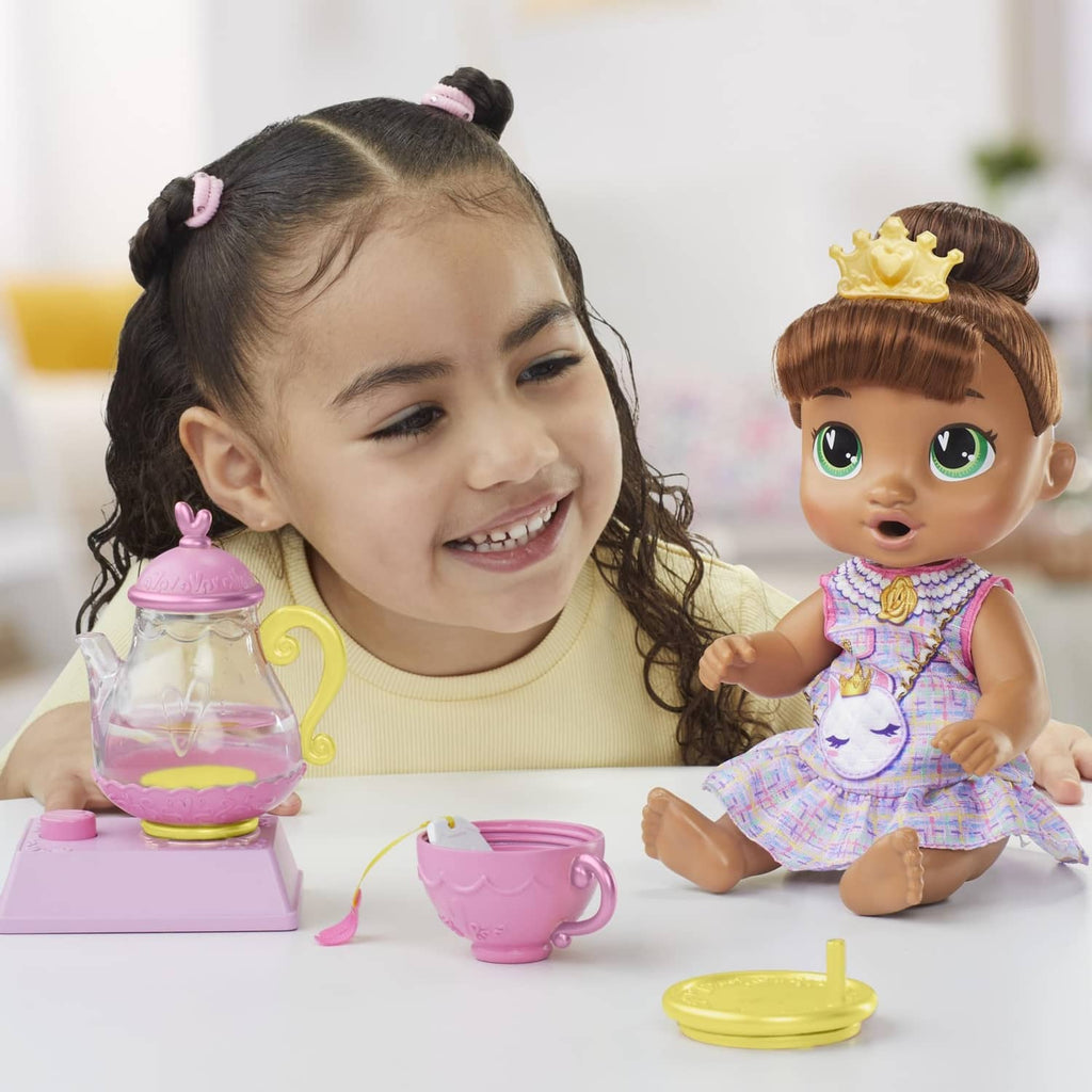 Child playing with Sophia Sparkle doll and purple teapot set on table
