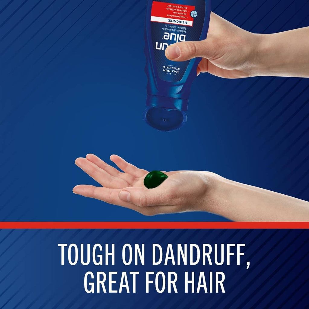 Medicated anti-dandruff shampoo bottle dispensing into open hands, blue cap