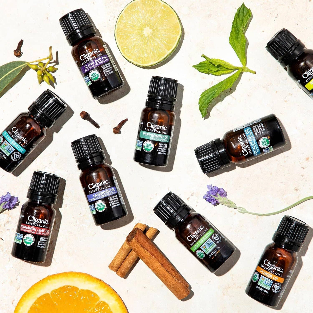 Lavender essential oil bottles with lemon slices and cinnamon sticks on light surface.