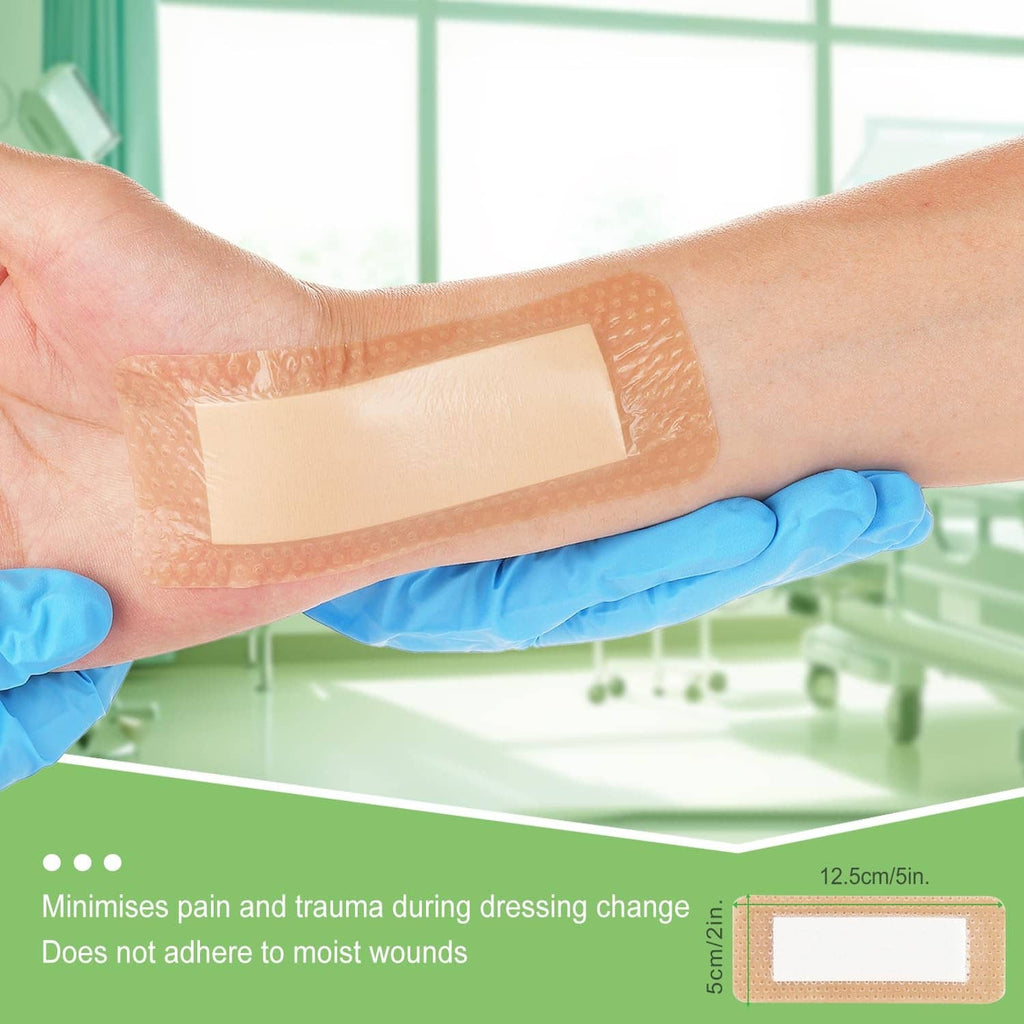 Tan silicone foam border dressing applied to a forearm, gloved hands