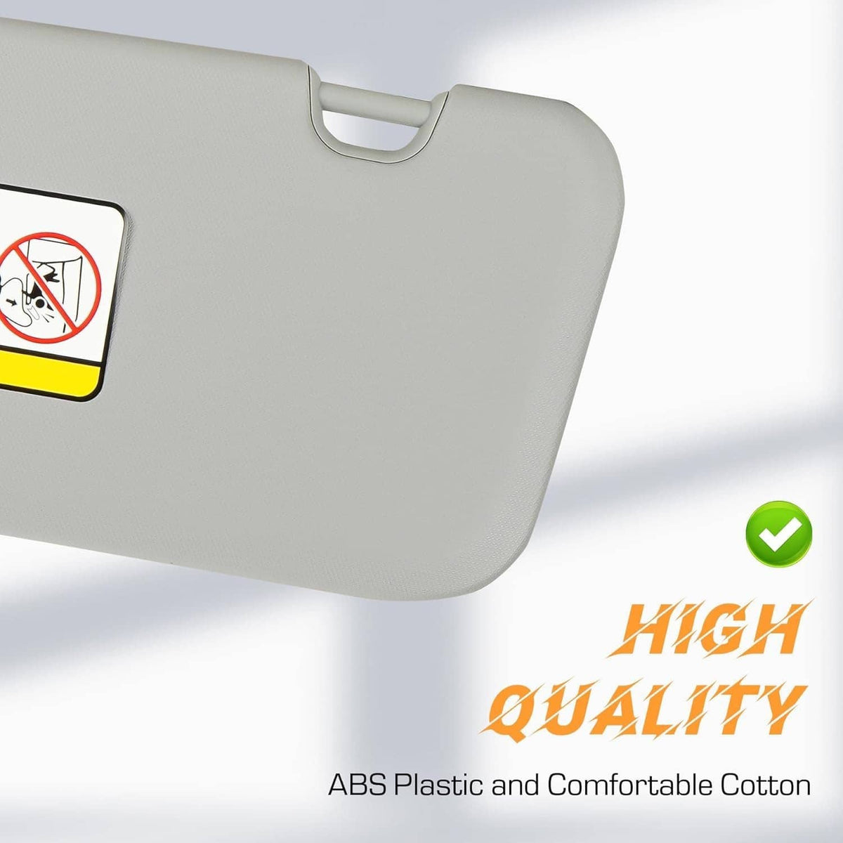 Gray sun visor close-up with side warning label and hanging tab