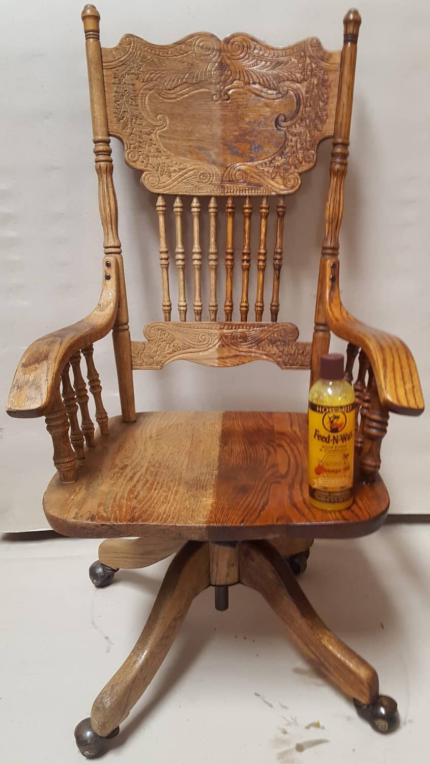 Howard Feed-N-Wax wood polish bottle beside carved wooden chair