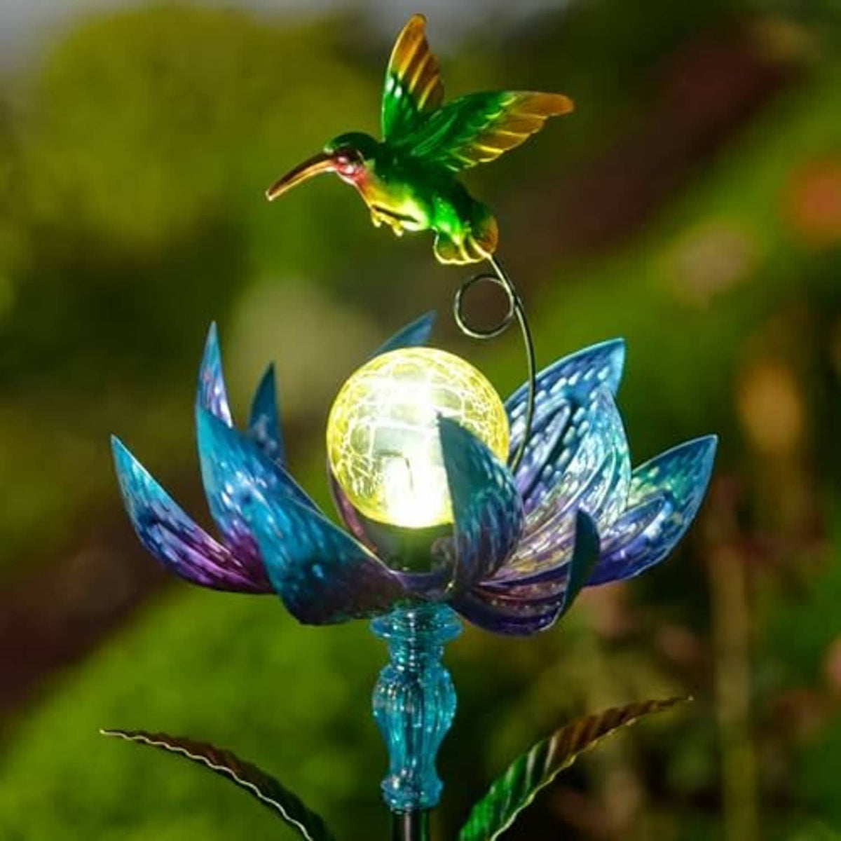 Solar wind spinner close-up with green hummingbird, glowing yellow LED orb, blue petals