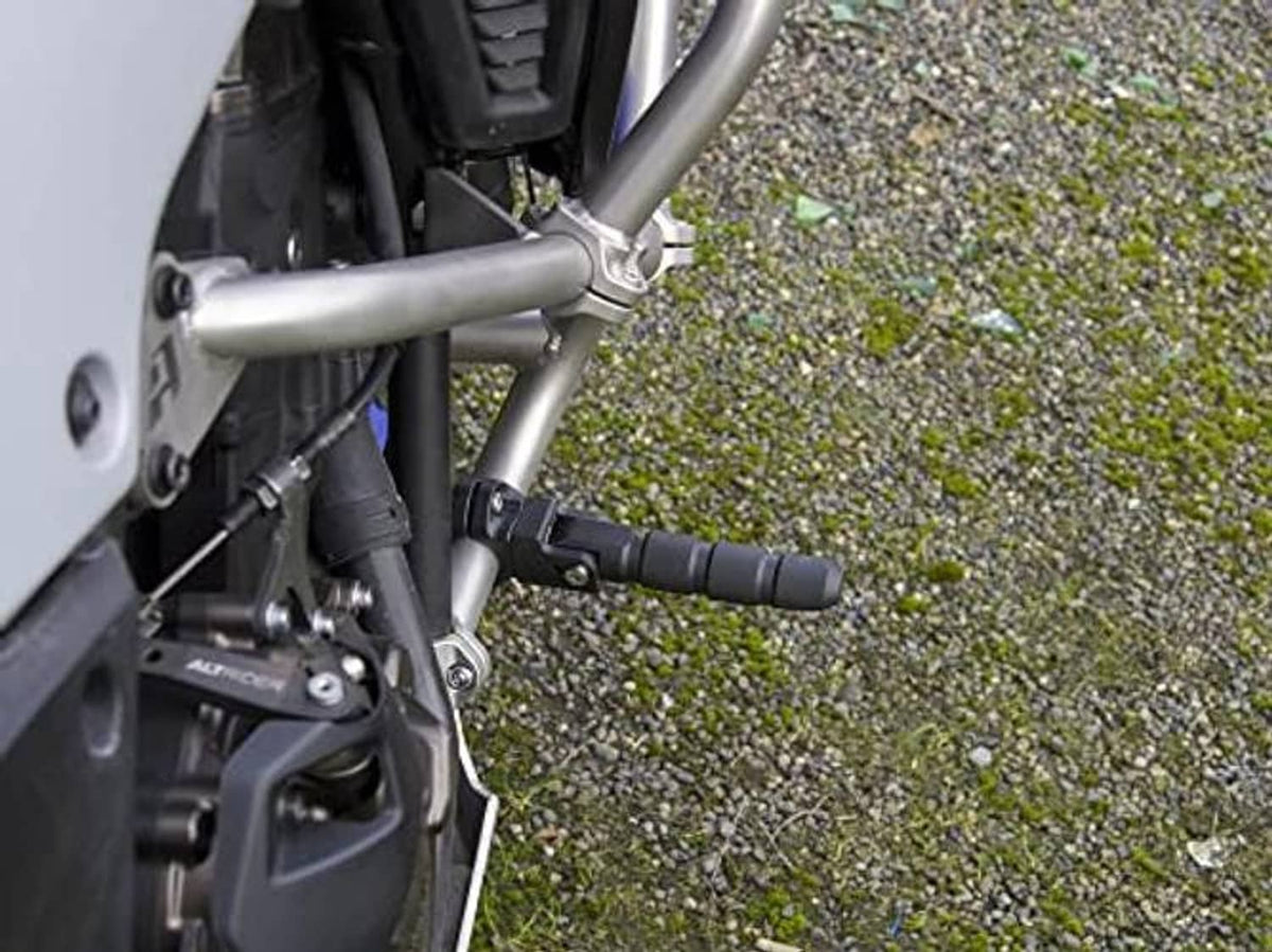 Installed black motorcycle highway peg on crash bar with textured foot surface