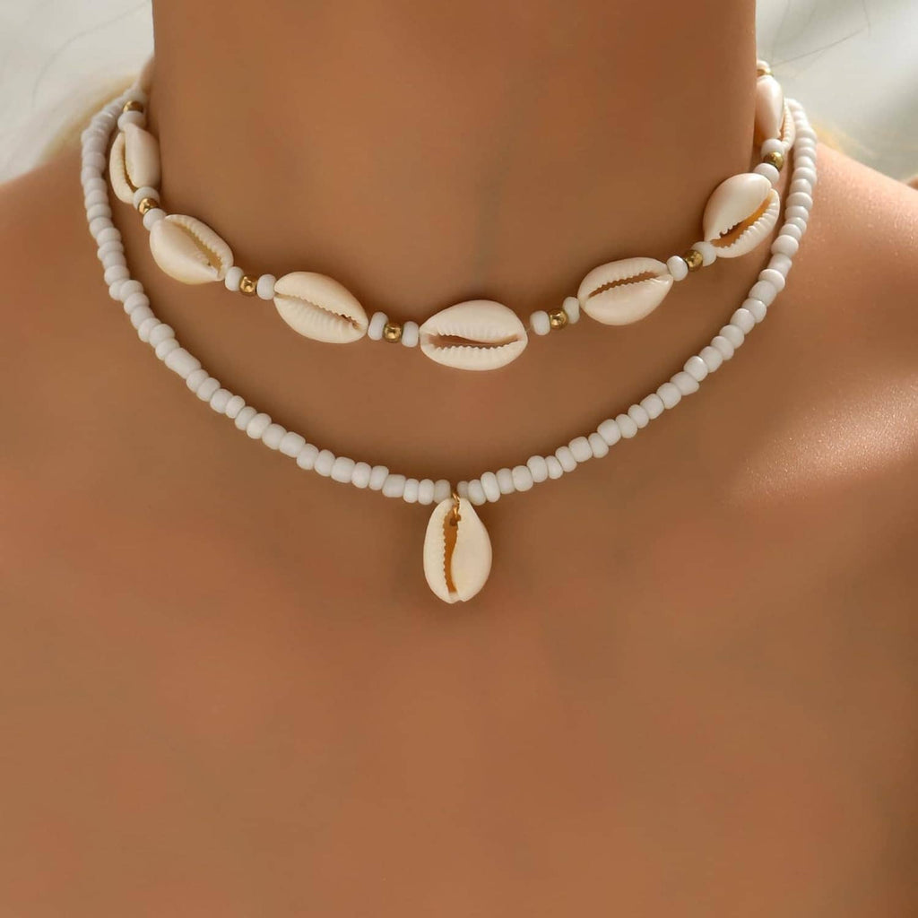 Handmade cowrie shell necklace with two white bead strands and hanging shell, gold-tone