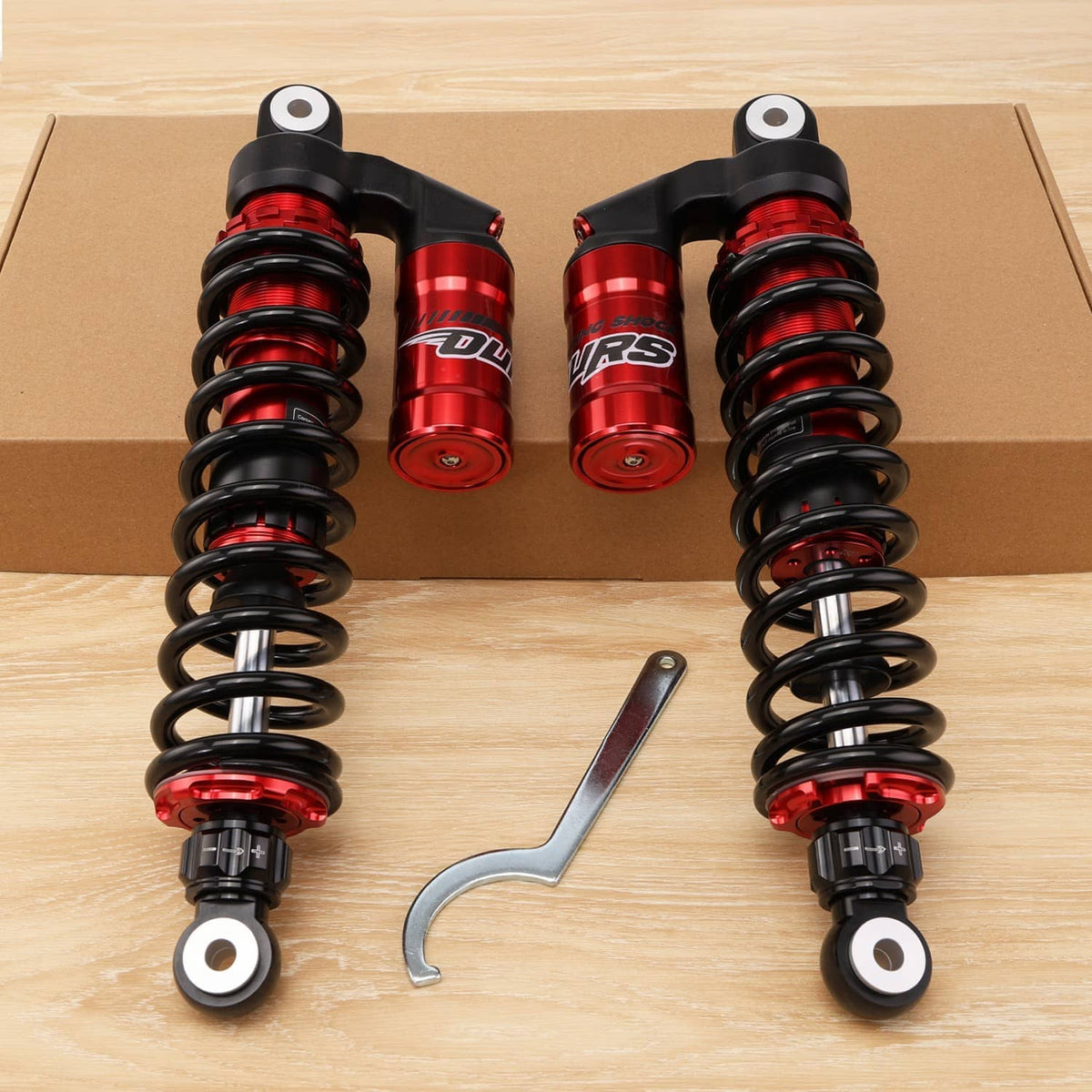 Front shock absorbers pair with red reservoirs, black springs, and mounting wrench