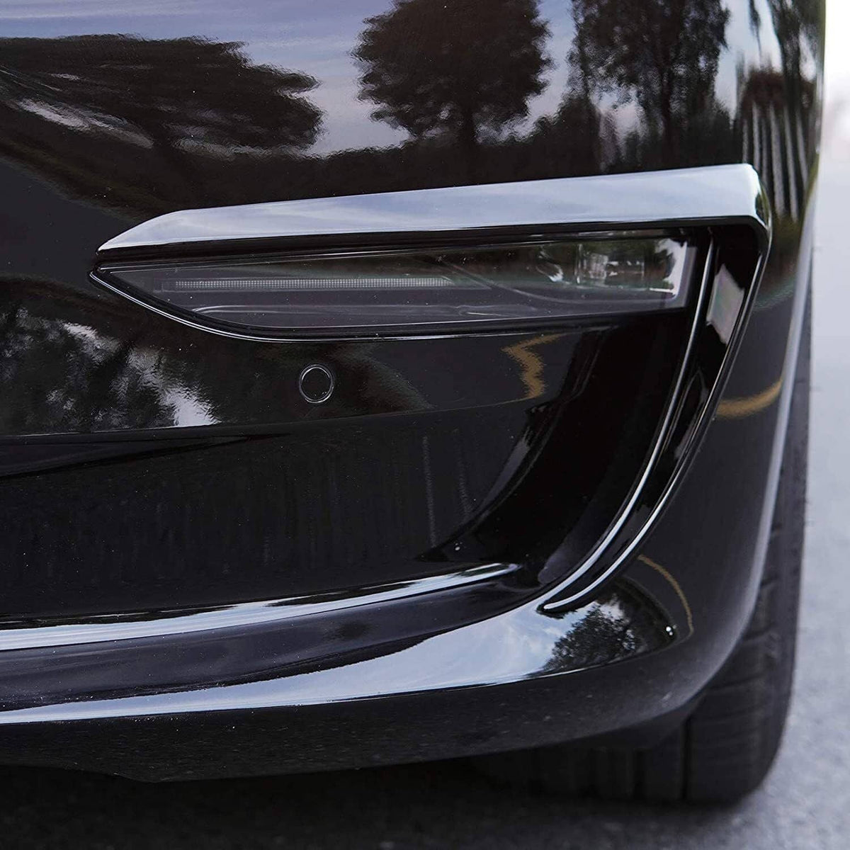 Gloss black fog light eyebrow cover trim installed near front fog light