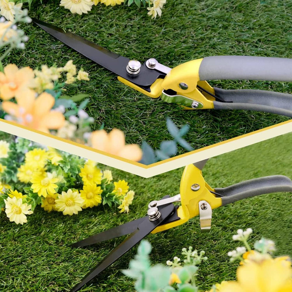Two yellow and gray grass shears with black blades on green lawn