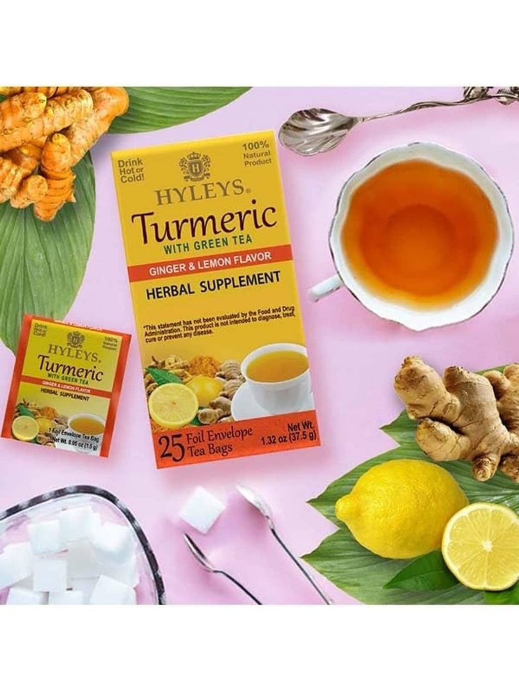 Turmeric green tea herbal supplement tea bags shown with brewed cup, lemon, and ginger
