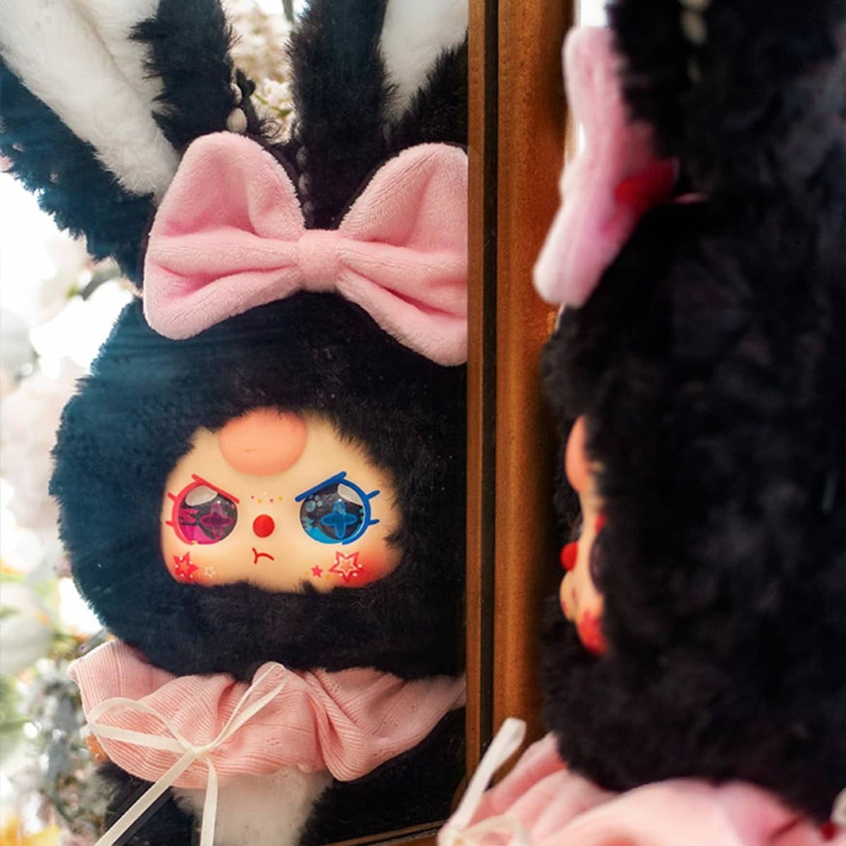Black rabbit plush blind box figure with pink bow and embroidered face