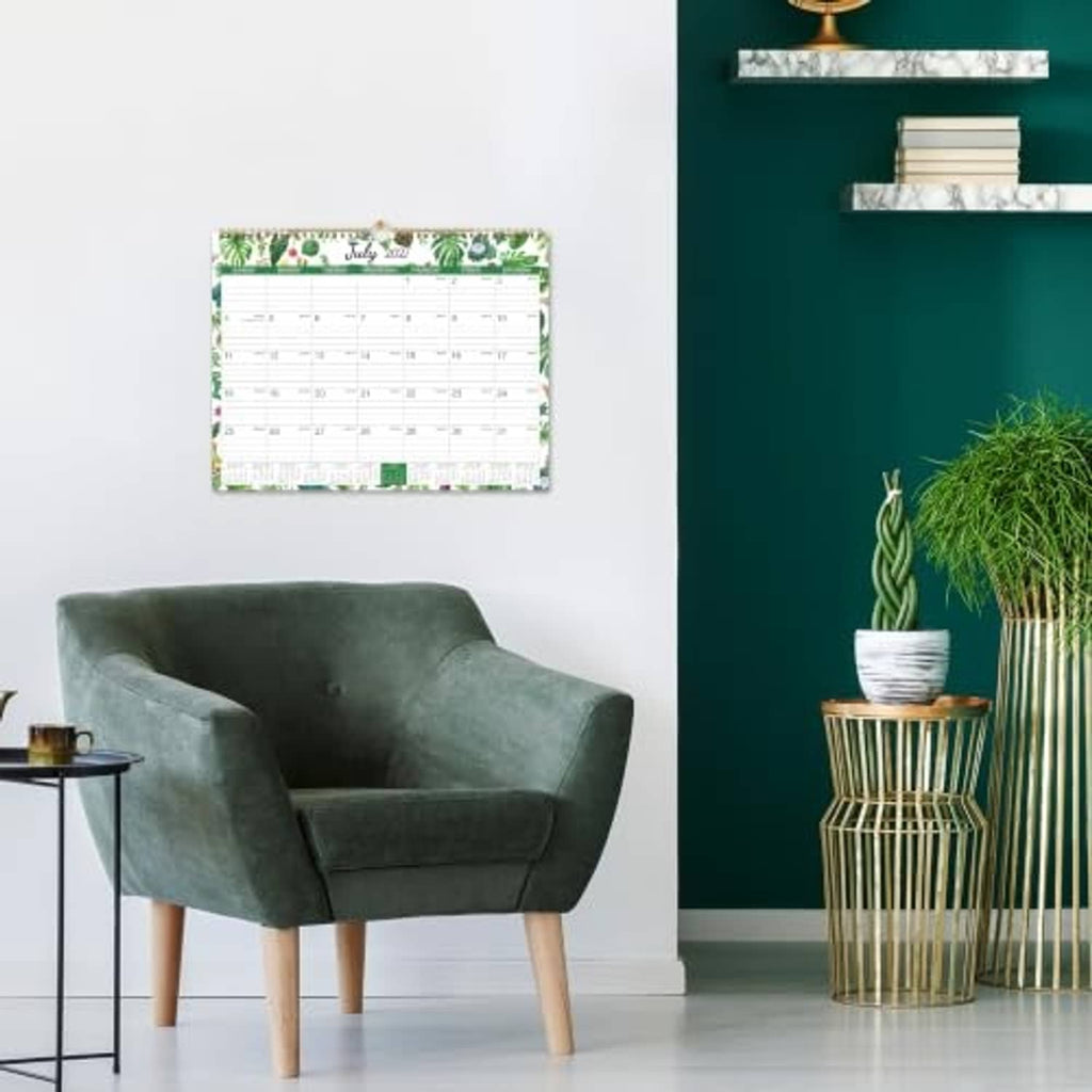 Wall calendar mounted on a wall above a chair, showing a monthly view