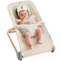 Cream baby bouncer seat with 3-point harness and ruffled headrest cushion
