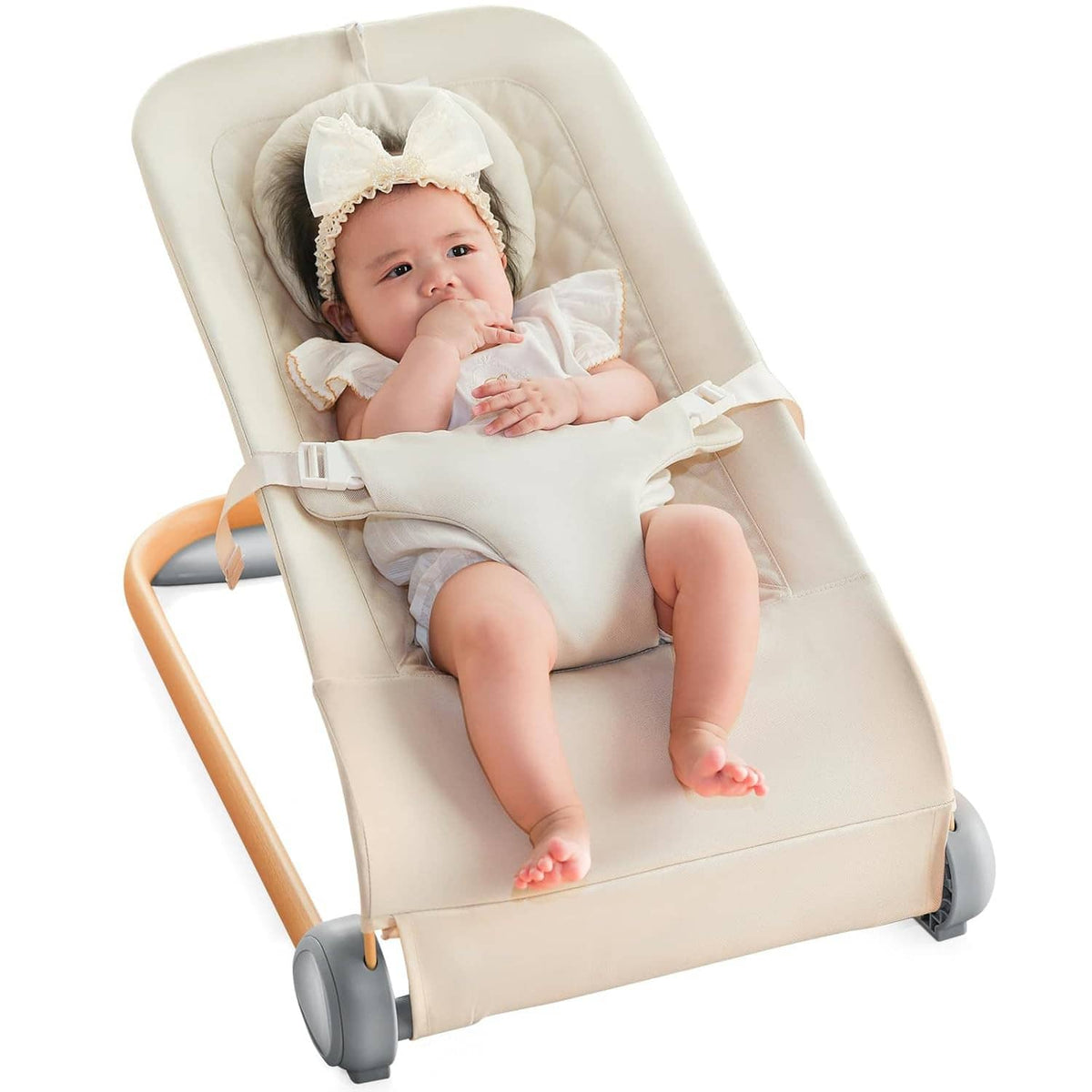 Cream baby bouncer seat with 3-point harness and ruffled headrest cushion